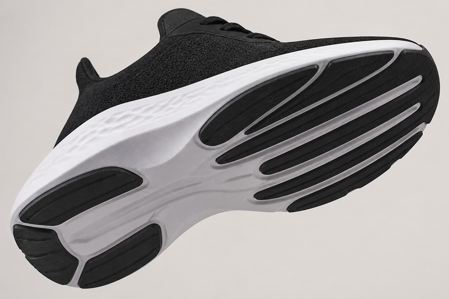 Road running shoe angled to show a smooth outsole with shallow flex grooves