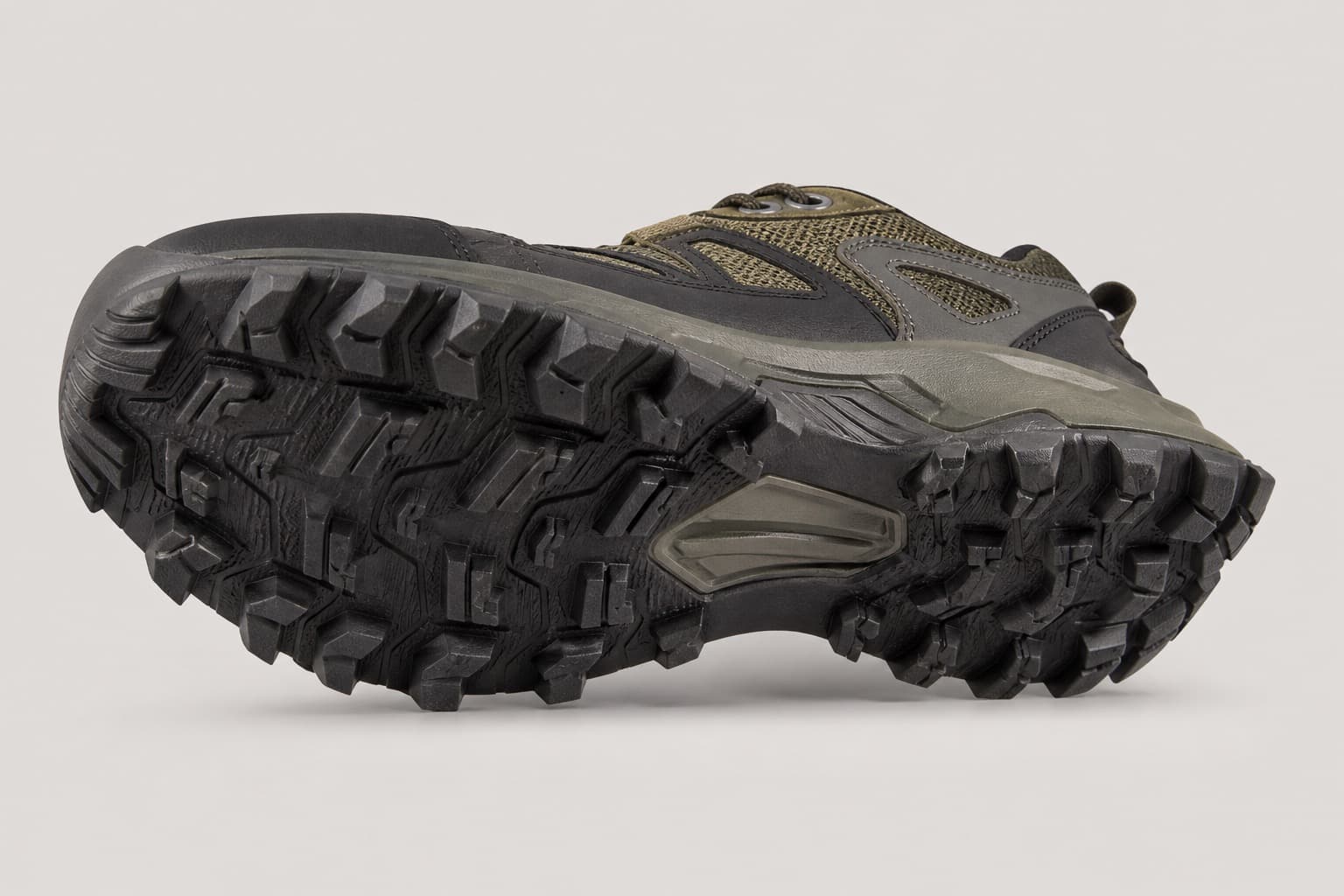 Trail running shoe angled to show deep lugged outsole and protective construction